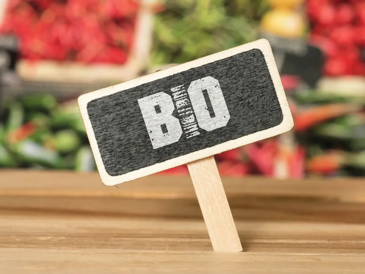 holzschild-mit-aufschrift-bio-vor-buntem-gemuese–symbol-fuer-biologische-und-nachhaltige-ernaehrung-bei-baluna-futter